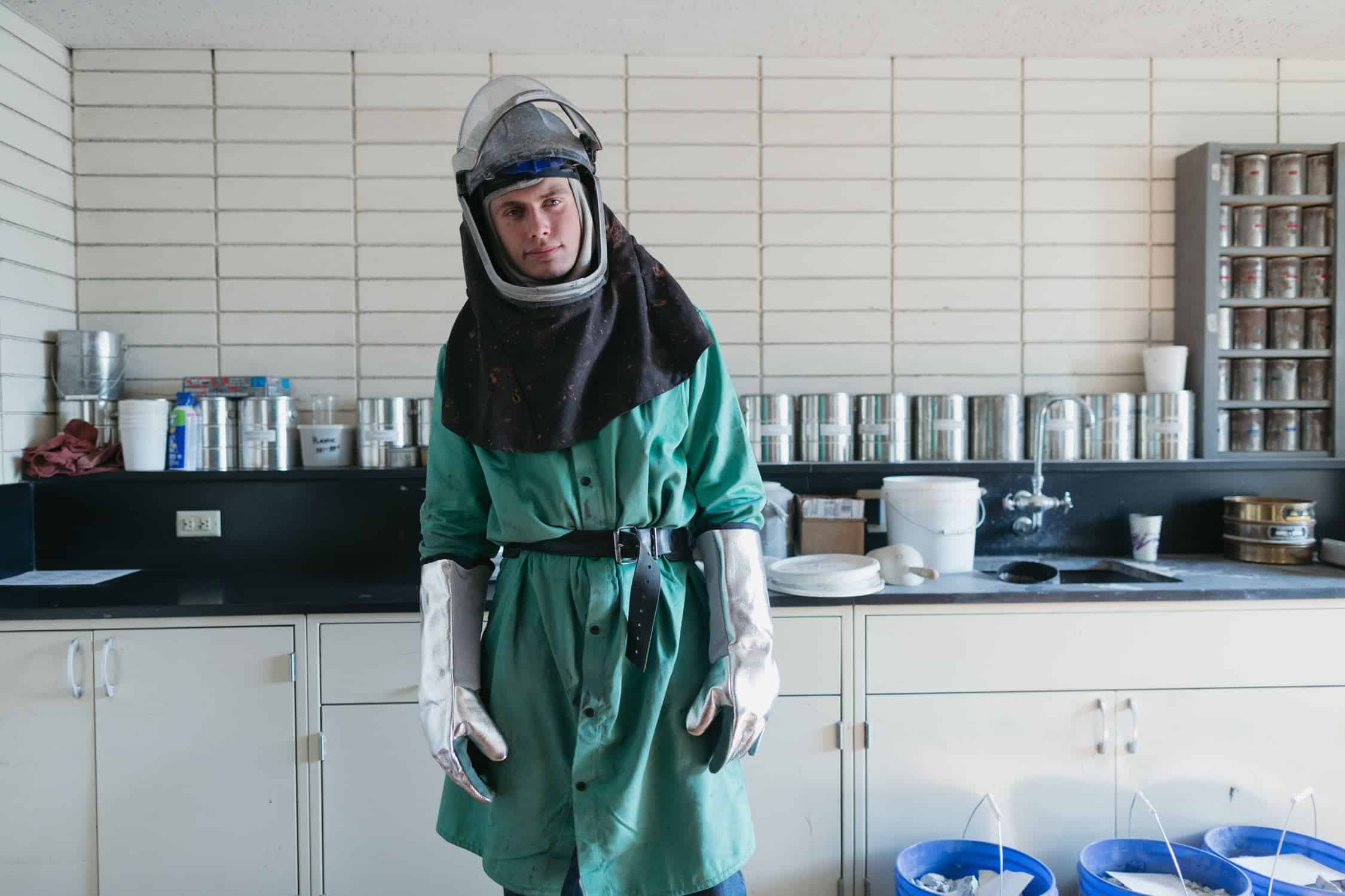 Man standing in hazmat suit with chemicals around him